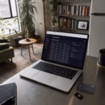 Laptop showing a fintech security dashboard beside a bank card and USB security key on a desk