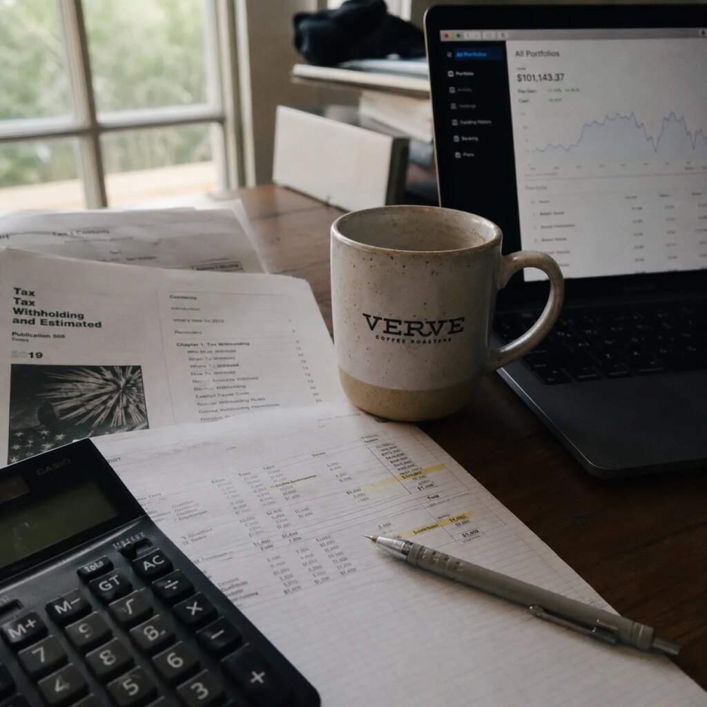 Tax documents and financial planning spreadsheet on a desk with natural side lighting