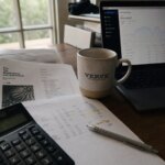 Tax documents and financial planning spreadsheet on a desk with natural side lighting