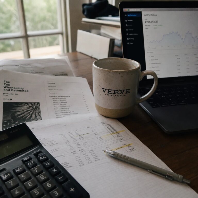 Tax documents and financial planning spreadsheet on a desk with natural side lighting